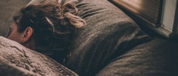 woman sleeping on bed under blankets