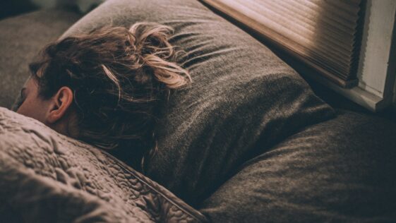 woman sleeping on bed under blankets