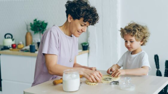 a woman and a child are making cookies